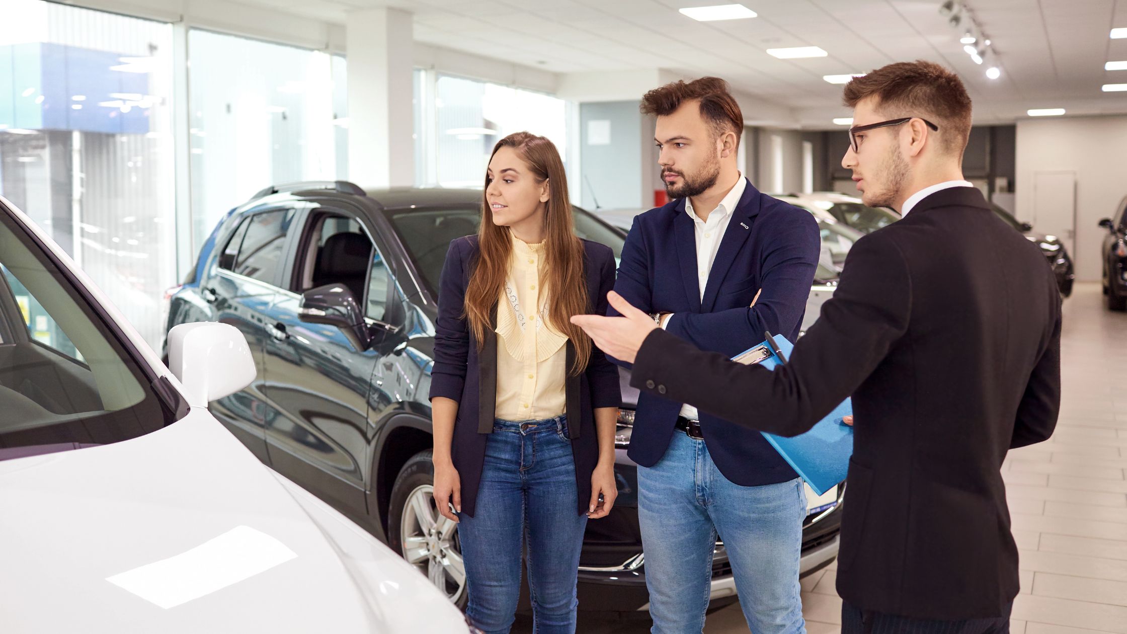 man and woman looking a vehicles with saleperson