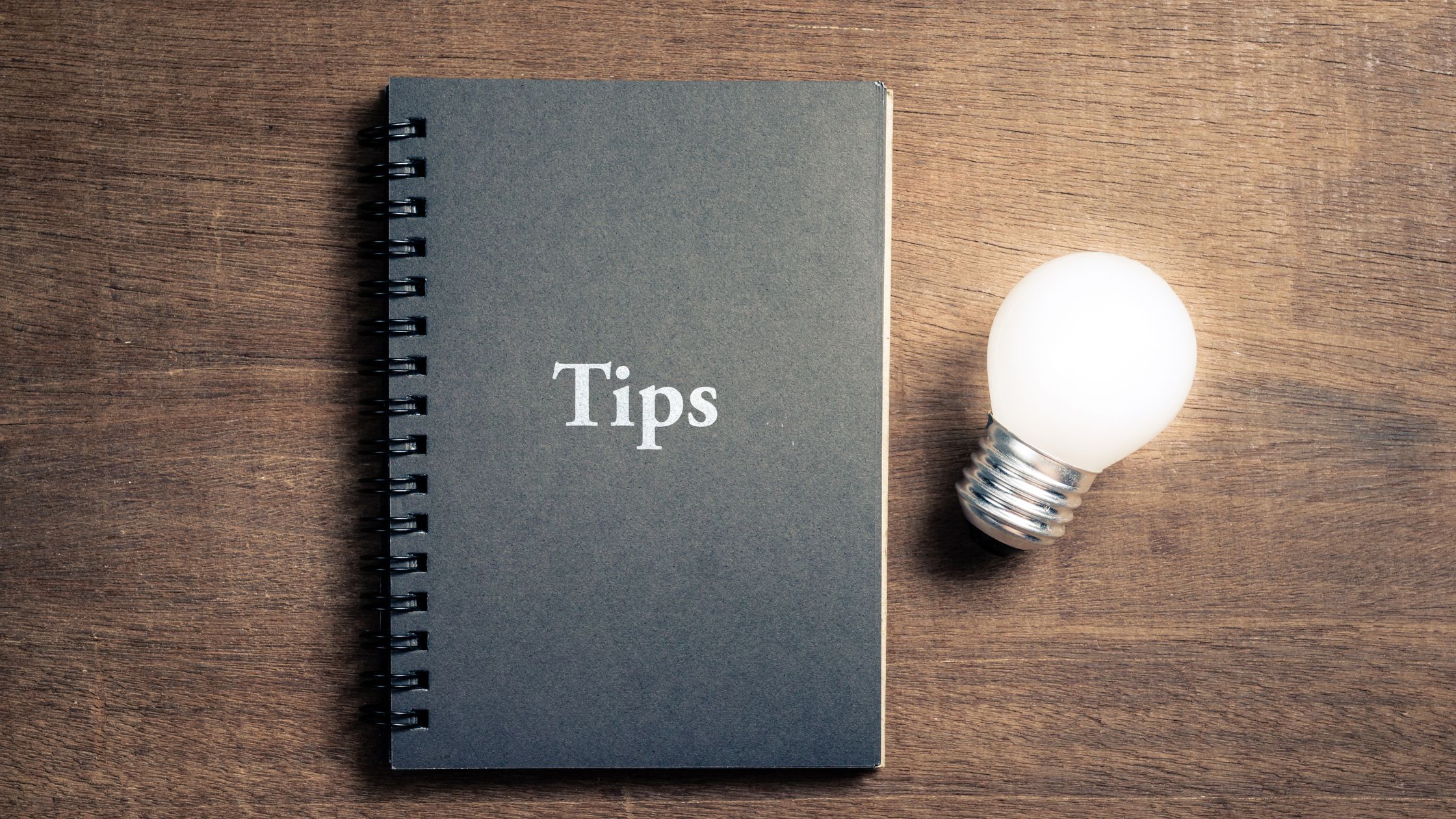 notebook with Tips on front next to light bulb